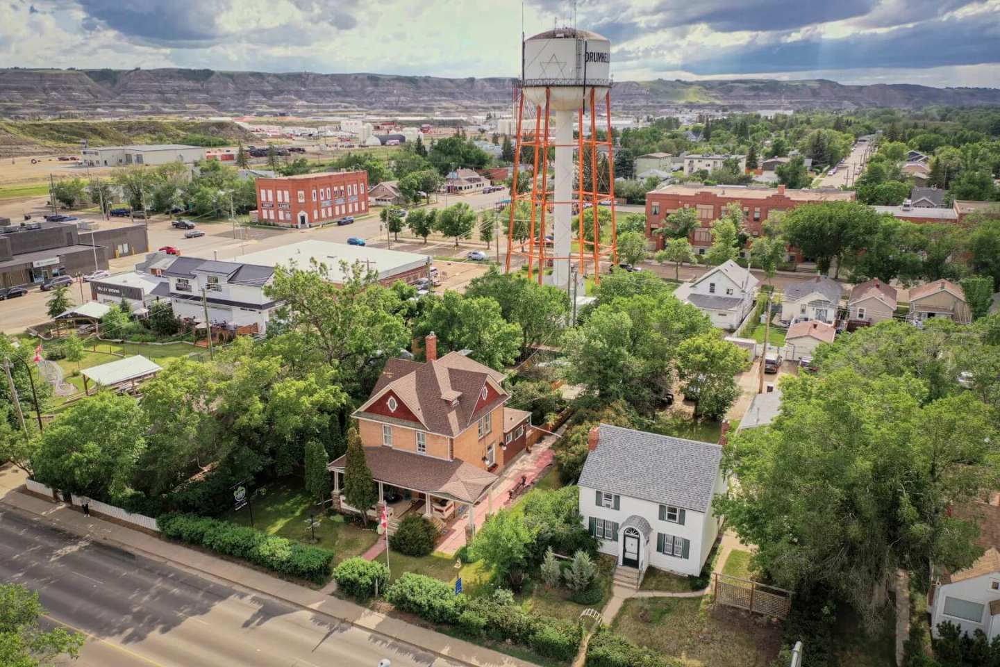 An aerial view of a small town with a water tower standing tall amidst the buildings and houses below.
