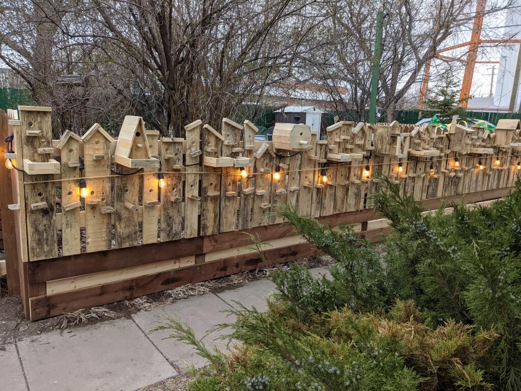 A fence made out of birdhouses